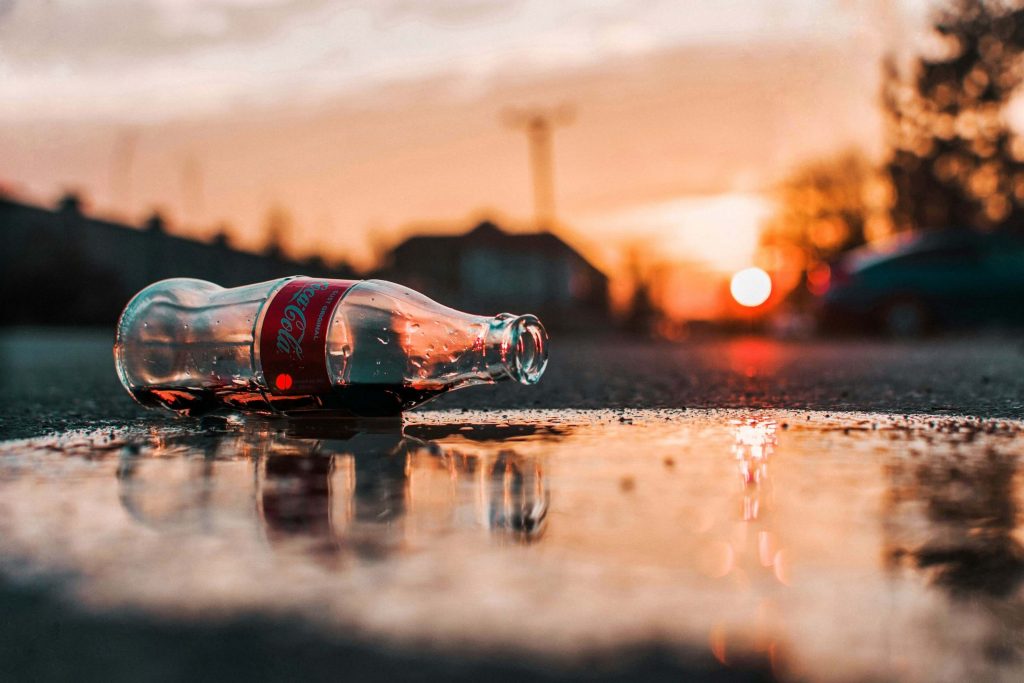Szklana butelka Coca-Coli na ziemi